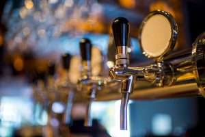 Row of stainless steel draft beer taps at Altstadt Brewery in Fredericksburg, Texas