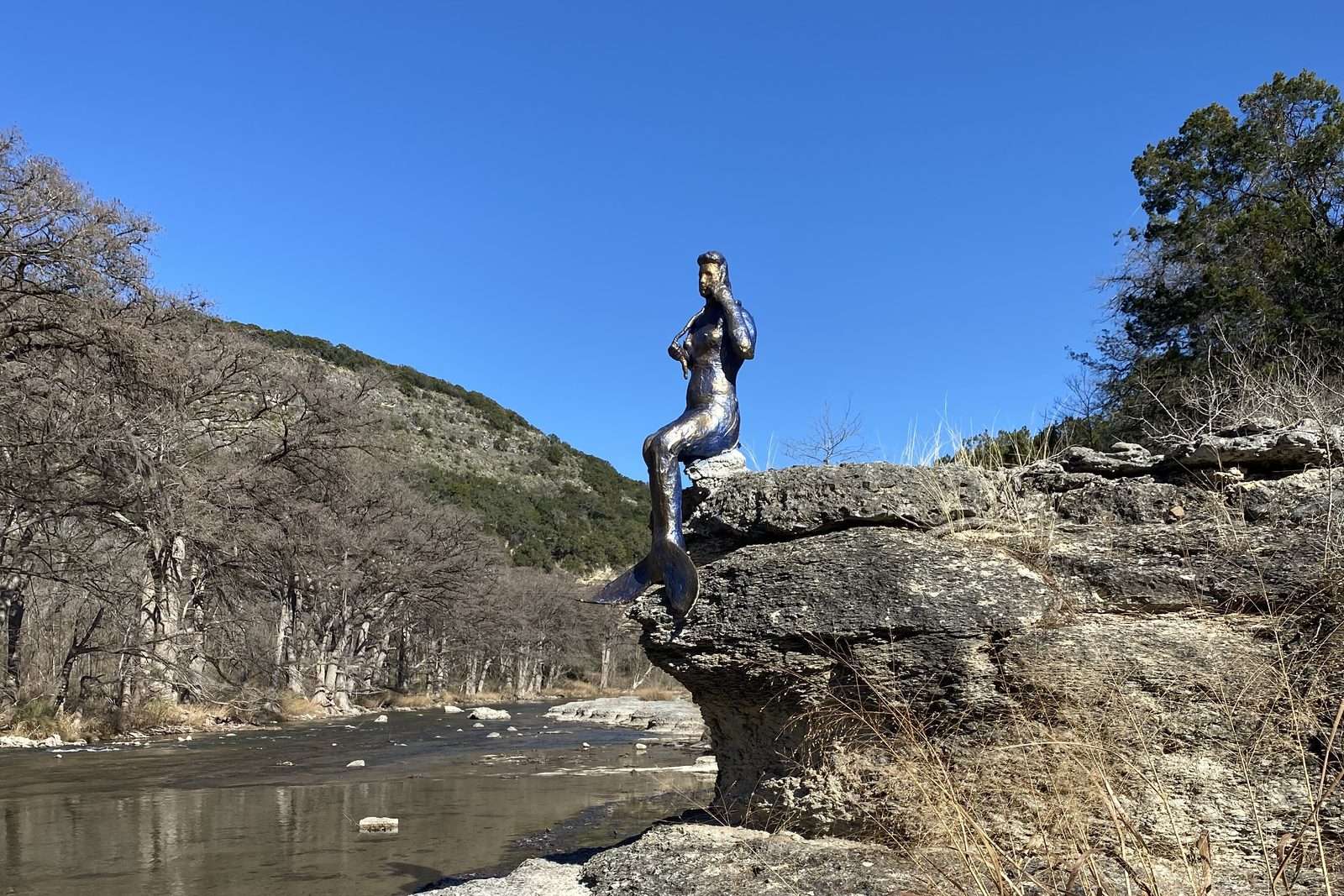 Mermaid statue on a rock overlooking the Guadalupe River