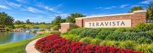 Teravista entrance sign with a pond, waterfall and red flower beds in Round Rock, Texas